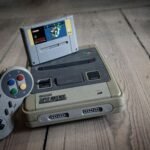 Vintage Super Nintendo style retro console and controller on wooden floor