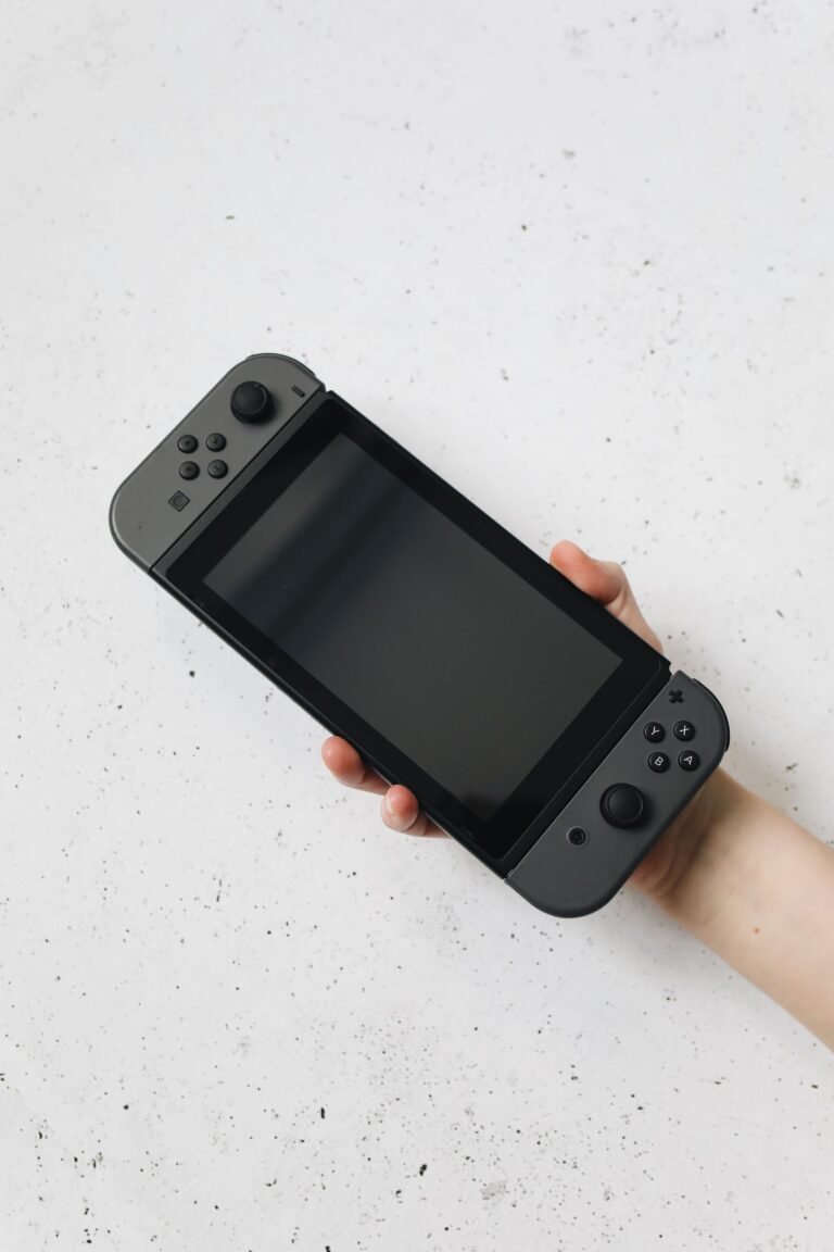 A hand holding a Nintendo Switch style handheld console