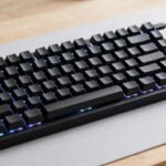 Compact 60% mechanical gaming keyboard with RGB lighting on a desk, ideal for small hands