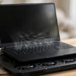 Gaming laptop on a cooling pad showing overheating vents while gaming