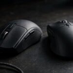 Wireless and wired gaming mice side by side on a dark desk for a latency comparison